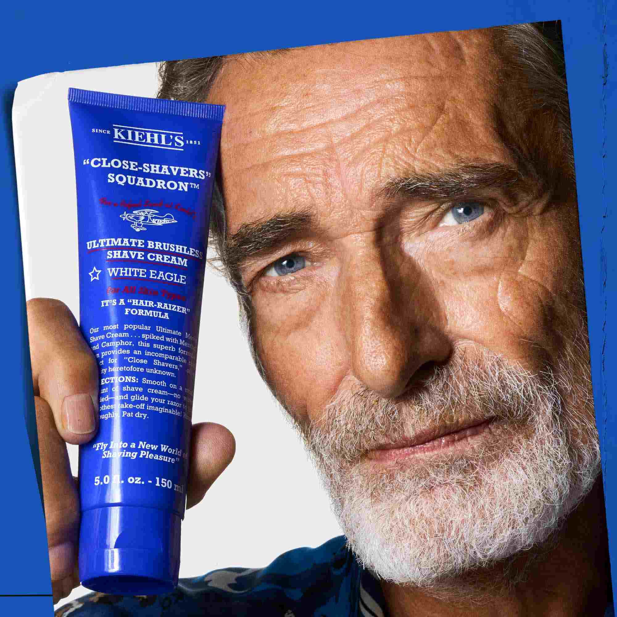 Un uomo che tiene un tubetto di Ultimate Brushless Shave Cream White Eagle.