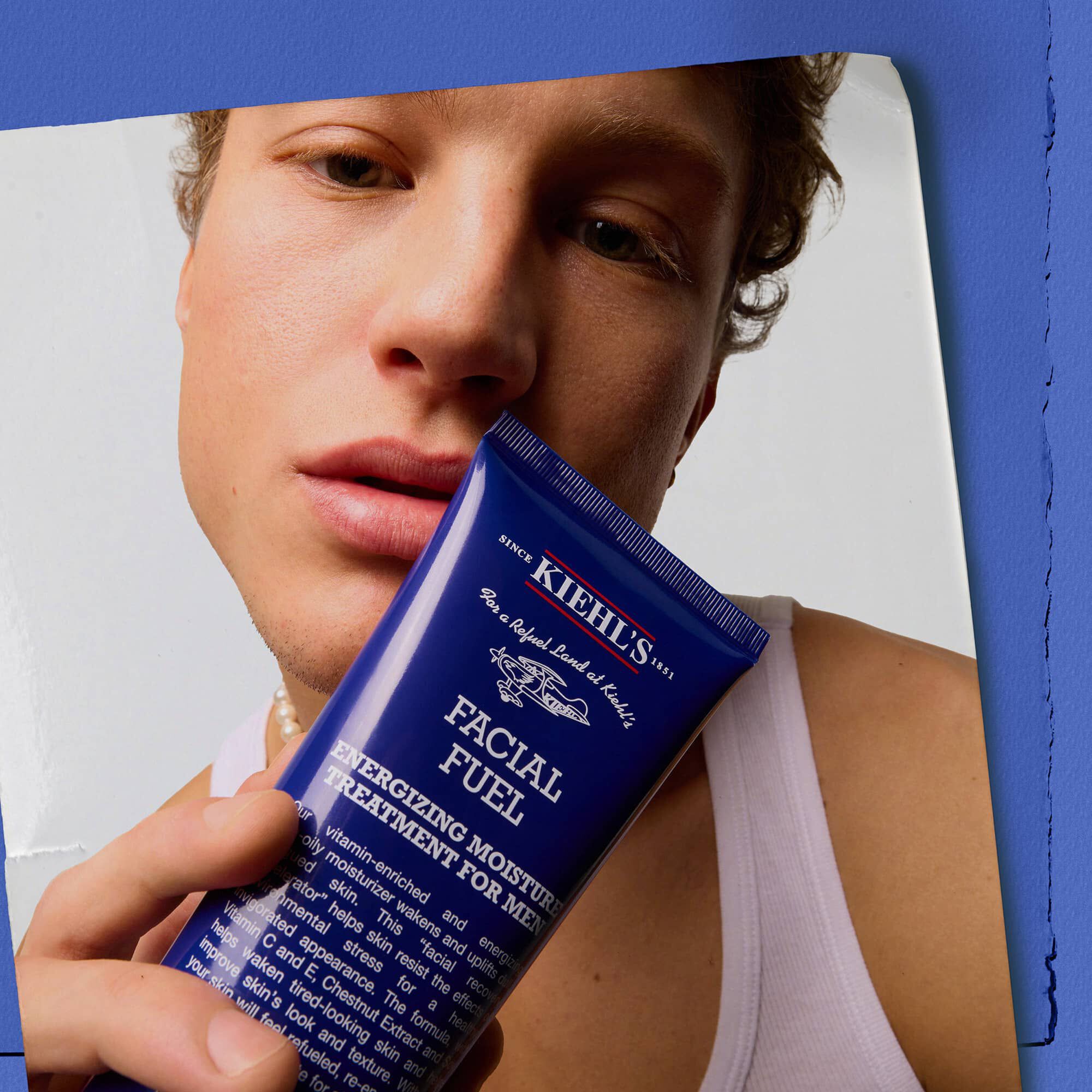 Modello con in mano il trattamento idratante viso energizzante per uomo Kiehl's Facial Fuel