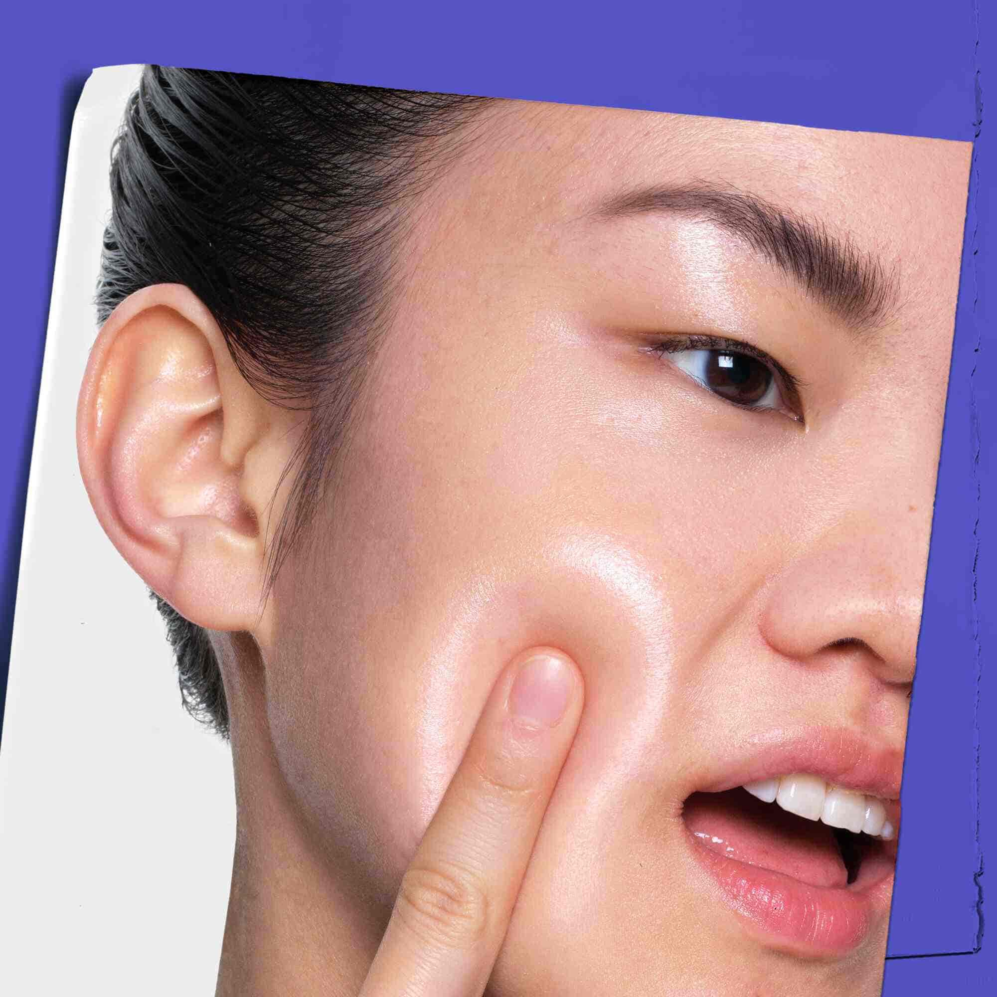 Una persona che applica Clearly Corrective Dark Spot Solution sulla pelle.